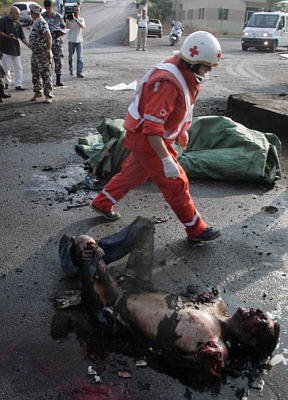 Quote A member of the Lebanese Red Cross walks past a badly burnt body in Beirut's port, which was targeted by Israeli warplanes, July 17 - Reuters Unquote Quote A member of the Lebanese Red Cross walks past a badly burnt body in Beirut's port, which was targeted by Israeli warplanes, July 17 - Reuters Unquote